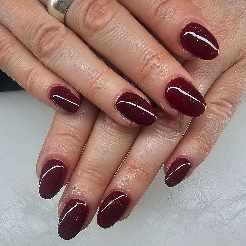 Dunkelroter Nagellack für eine Nagelverlängerung