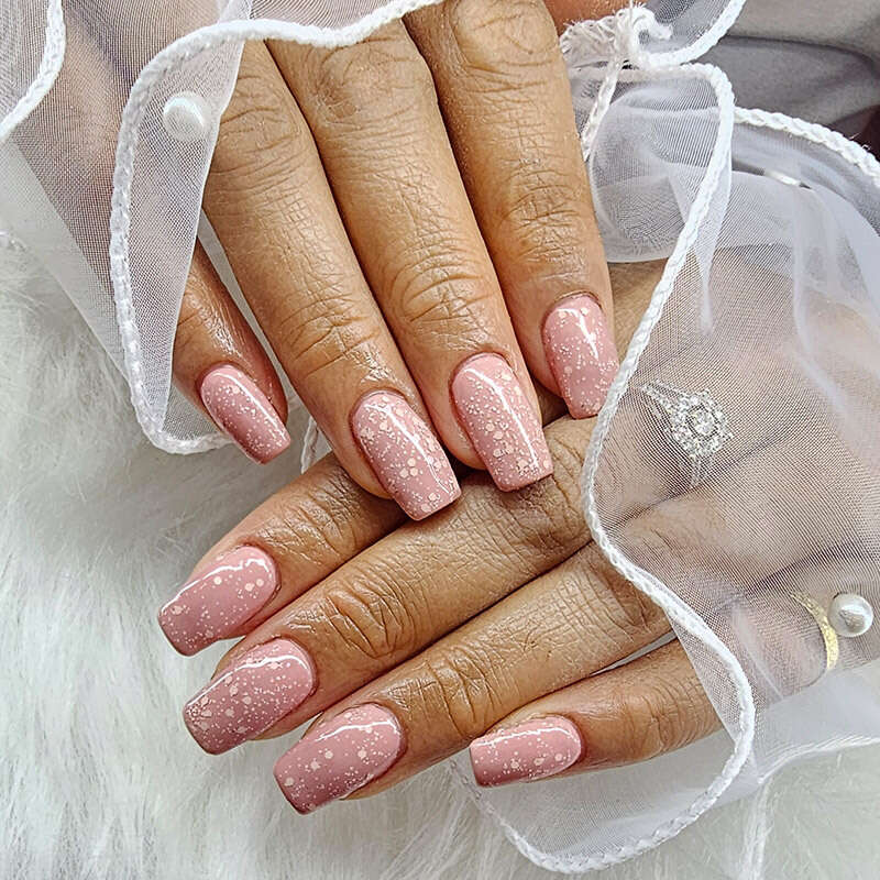 Maniküre mit Nagellack in Rosa mit Punkten
